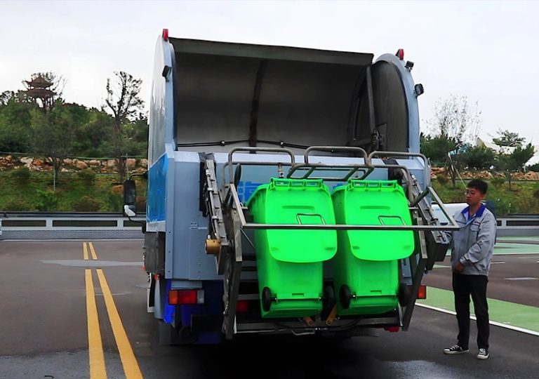 Rear loading dustbin cleaning truck holding green waste bins for enclosed washing